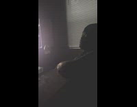 Guy wearing beanie sings in dark room 