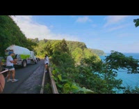 Man angles on the highway while a truck passes by