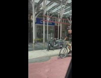 Guy bikes with skeleton behind him 