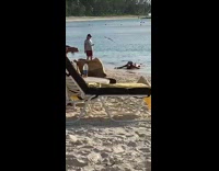 Woman gets up slowly from shore for picture