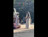 Woman in bikini poses beside beach wedding