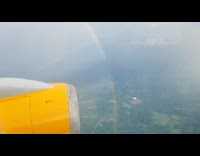 Filmer on plane shows rainbow outside window