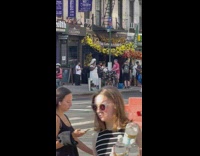 Woman waits for bus in white wig and dress 