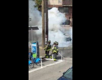 Firemen sprays water put out car fire