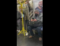 Guy on subway with yellow coat rack 