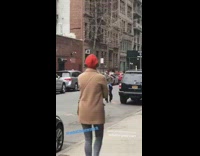 Guy practices flute while walking on the street in New York
