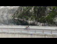 Three guys ride bicycles across bridge drone 