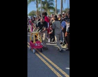 Man skates with son on a cozy coupe 