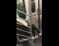 Woman Drinks From Brown Bag on Subway