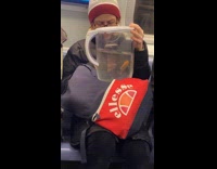 Woman holds fish in pitcher rides subway