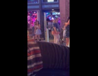 Woman shiny green dress dances on street