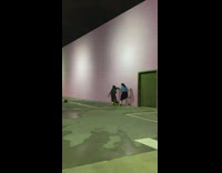 Woman in black dress parkours the pink wall