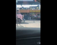 Man sit bumper pink truck raise shirt