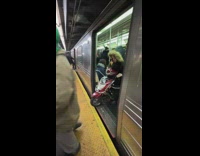 Woman exits train with red motorcycle 
