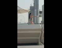 Woman in green bikini records herself for seflie 