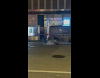 Guy having photoshoot above steaming manhole on street