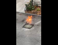 Catch basin on the street is on fire 