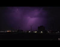 Slow motion lightning above windmills night sky