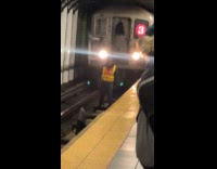 Subway worker picks up umbrella on rail