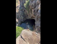 Man shirtless jumps from cliff to water