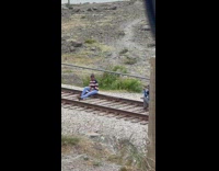 Girl zigzag sweater sit on train tracks