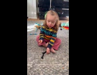 Young girl try to wear small toy boots