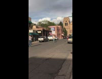 Lady Walks and Stops for Photos Near Old Town Stores 