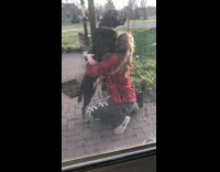 Black dog jump hug owner red jacket