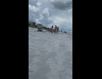 Four girls dance together beach cloudy umbrella
