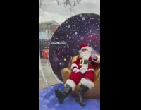 Guy dressed as santa in snow globe 