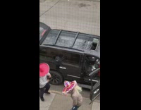 Two men wear sombreros and dance outside on sidewalk to Mexican music