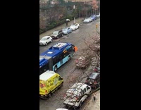 Lady with orange umbrella blocks blue bus