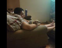 Dog sits on man watches soccer game