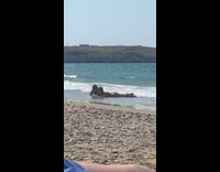 Man and Woman lie down and caught filmer at the beach