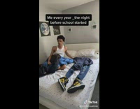 Guy sleeping and waking up next to school outfit laid on bed