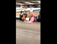 Two people play cello in old english outfits
