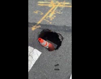 Man shows growing sinkhole on road