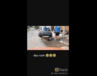 Guy tries to help coworker put wheel on rim