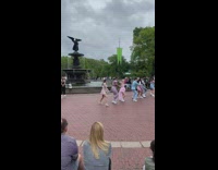 People in matching outfits doing a choreographed dance at the park