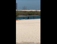Man flexes muscles for photo at beach