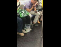 Guy in purple shirt picks nose and eats boogers while on blue phone on subway