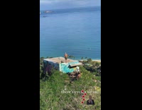 Shirtless guy jump flip roof drone beach