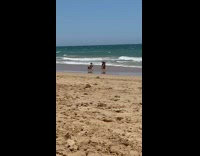 Woman in bikini and a hat tiktok dance at the beach