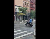 Guy on scooter in the street with wheel on skateboard