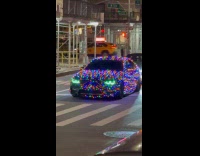 Car wrapped around with colorful Christmas lights 