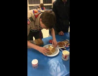Boy Scout builds a graham cracker house, house falls when he does a thumbs up at the camera 