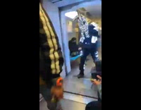 Guy in light up costume and helmet dances train 