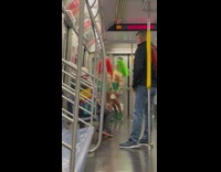 Two women in troll costumes spinning their spinners on subway