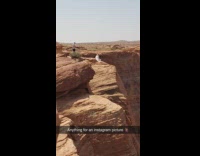 White dress girl sits edge canyon rock 