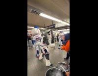Band and baseball mascots at subway station